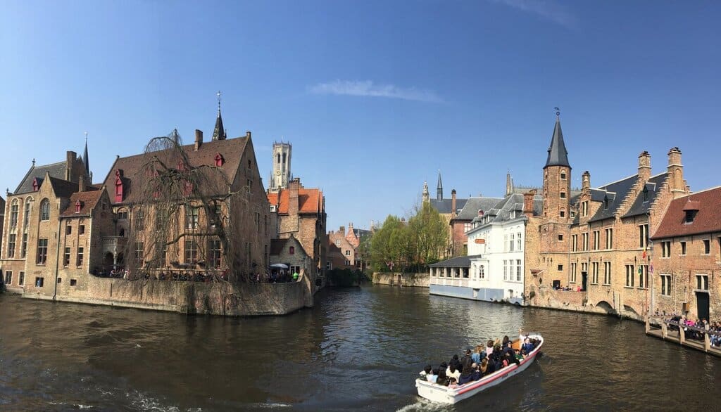 Bruges canal with a boat going through it 