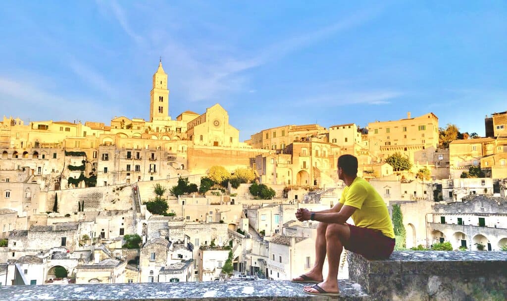 Chris Heckmann sitting on a ledge in Matera