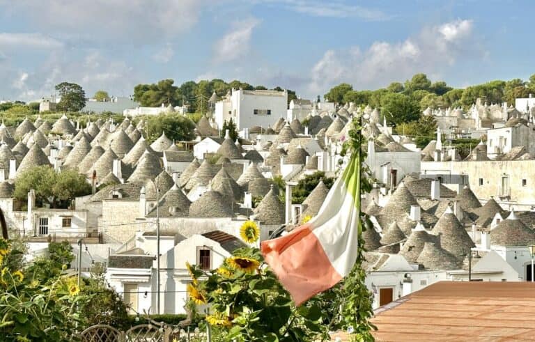 Alberobello, Puglia with an Italian flag in the foreground
