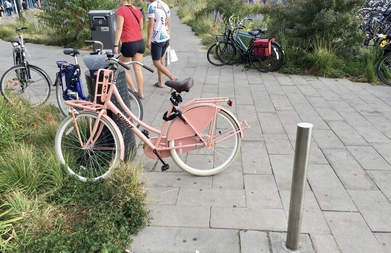 a pink bike in the Netherlands blocking the sidewalk