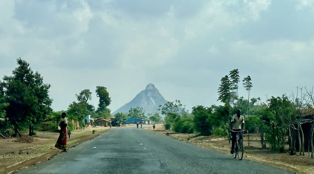 a paved road in Malawi with a steep mountain in the background