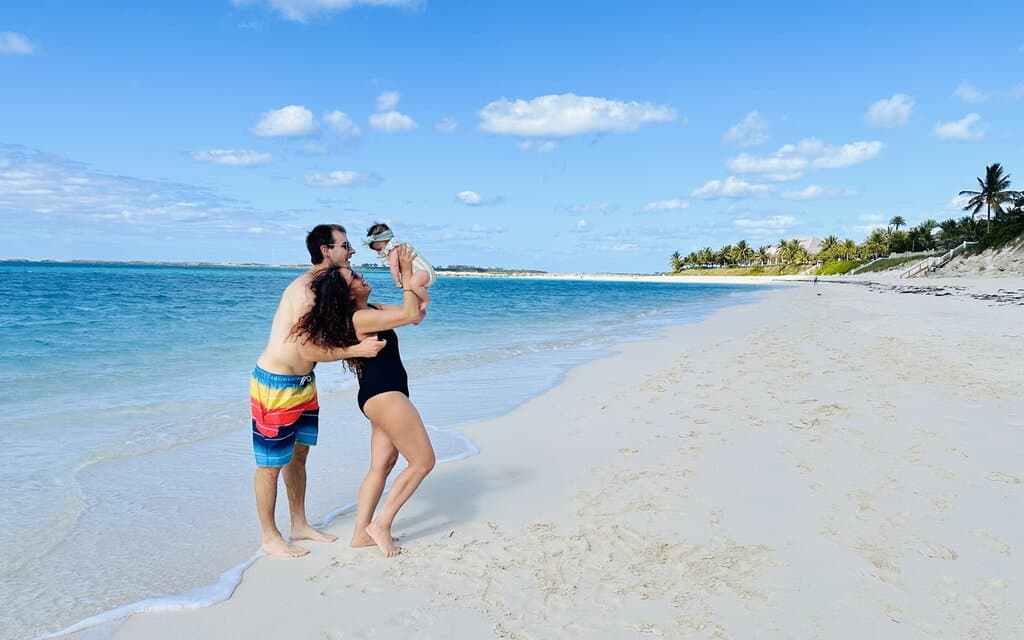 Chris Heckmann and Nimarta Bawa with baby at Cabbage Beach in The Bahamas