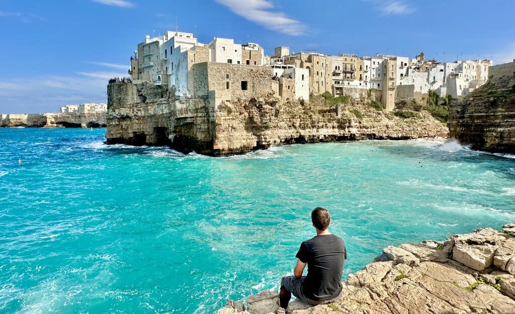 Chris Heckmann looking at the old town of Polignano a Mare across the sea