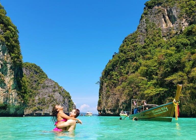 Chris Heckmann and Nimarta Bawa hugging in Pi Leh Bay in Thailand