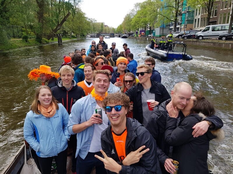 expats on a boat in Amsterdam during King's Day