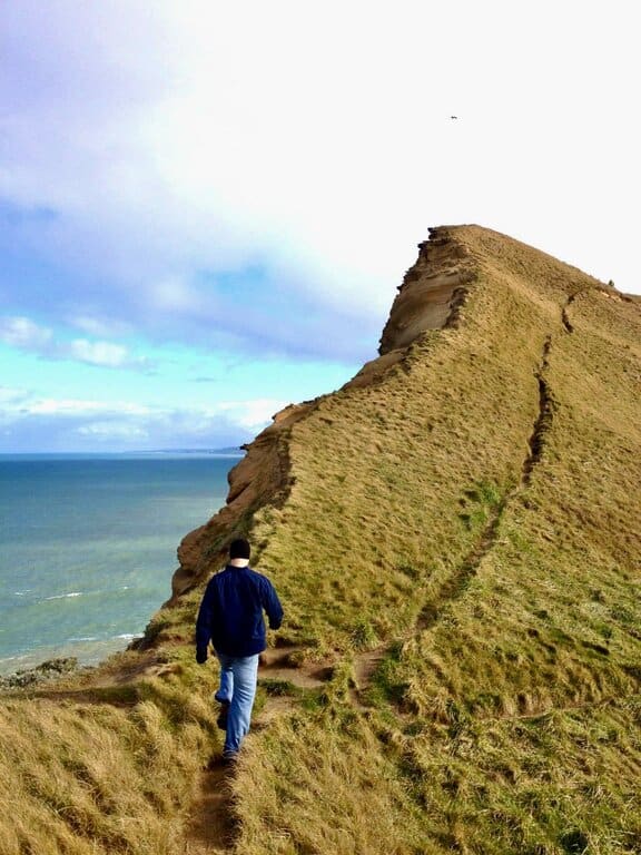 A hiker along the coast in Castelpoint New Zealand
