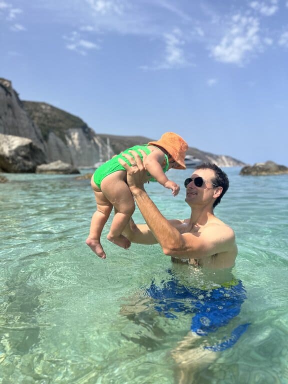 Baby playing in the water with dad in Greece